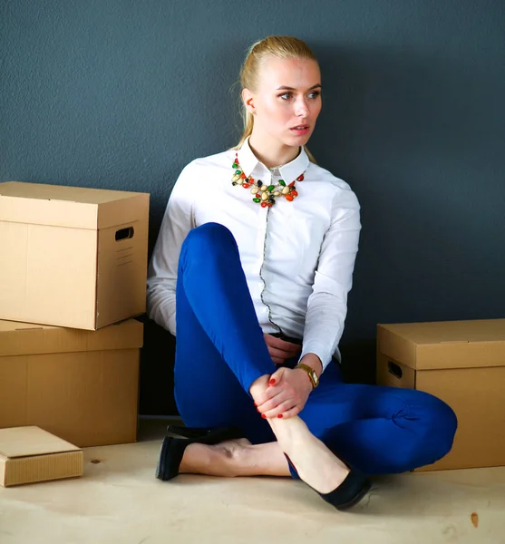 Kobieta siedzi na podłodze w pobliżu pudełek z laptopem — Zdjęcie stockowe