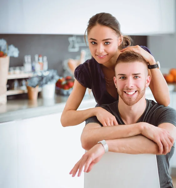 Belo jovem casal sentado na cozinha em casa — Fotografia de Stock