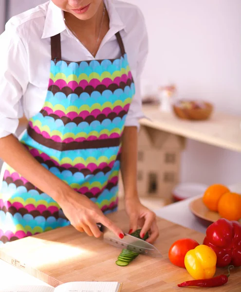 Młoda kobieta cięcia warzyw w kuchni — Zdjęcie stockowe