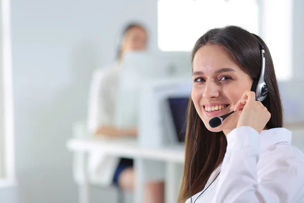 Uomo d'affari sorridente o operatore helpline con auricolare e computer in ufficio — Foto Stock