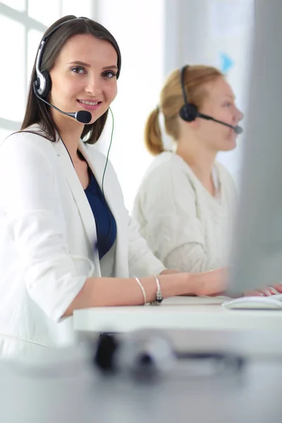 Mosolygós üzletasszony vagy segélyvonal-kezelő fülhallgatóval és számítógéppel az irodában — Stock Fotó