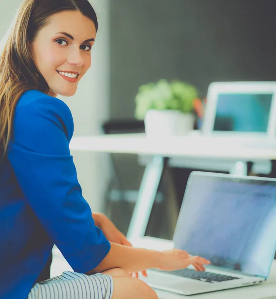 Mujer sentada en el escritorio con portátil — Foto de Stock