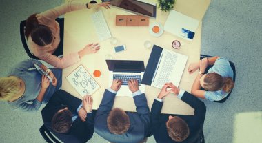 İş adamları toplantıda, ofiste oturup tartışıyorlar.