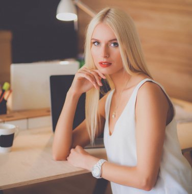 Moda tasarımcıları stüdyoda çalışıyor. Masanın üzerinde oturuyorlar.