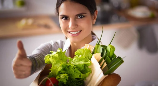 Mujer joven sosteniendo bolsa de la compra de comestibles con verduras y mostrando ok — Foto de Stock