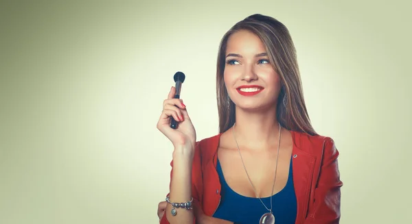 Joven hermosa mujer sostiene en cepillo de mano para el maquillaje — Foto de Stock