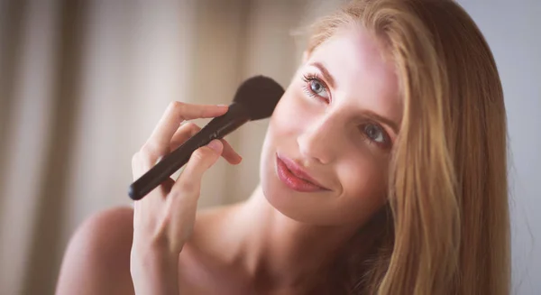 Hübsche Frau schminkt sich mit Pinsel — Stockfoto