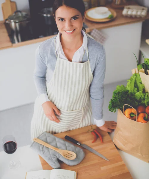 Vrouw maken van gezonde voeding staande glimlachend in keuken — Stockfoto