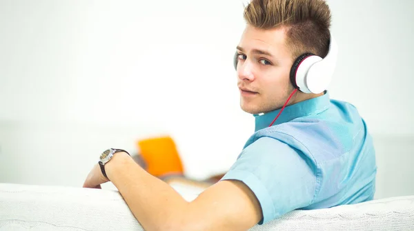 Man listening music in headphone on the sofa at home — Stock Photo, Image