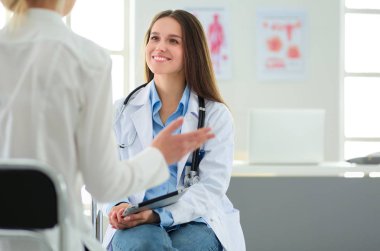 Doktor ve hasta masada otururken bir şey tartışıyorlar. İlaç ve sağlık hizmetleri kavramı