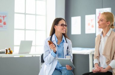 Doktor ve hasta masada otururken bir şey tartışıyorlar. İlaç ve sağlık hizmetleri kavramı