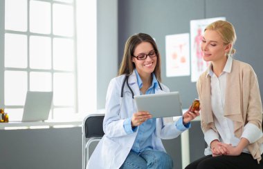 Doktor ve hasta masada otururken bir şey tartışıyorlar. İlaç ve sağlık hizmetleri kavramı