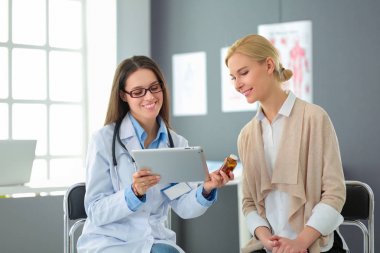 Doktor ve hasta masada otururken bir şey tartışıyorlar. İlaç ve sağlık hizmetleri kavramı