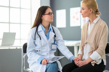 Doktor ve hasta masada otururken bir şey tartışıyorlar. İlaç ve sağlık hizmetleri kavramı