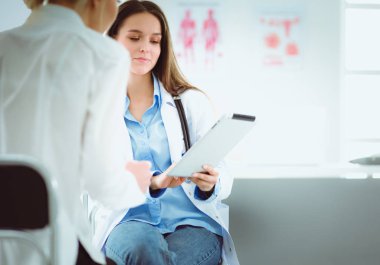 Doktor ve hasta masada otururken bir şey tartışıyorlar. İlaç ve sağlık hizmetleri kavramı