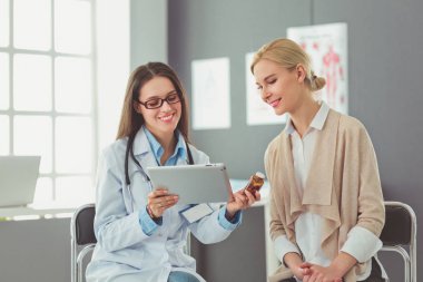 Doktor ve hasta masada otururken bir şey tartışıyorlar. İlaç ve sağlık hizmetleri kavramı