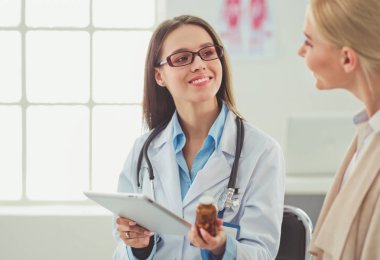 Doktor ve hasta masada otururken bir şey tartışıyorlar. İlaç ve sağlık hizmetleri kavramı