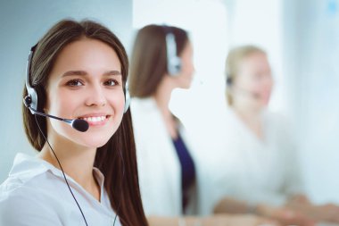 Ofisinde kulaklık ve bilgisayarla gülümseyen iş kadını ya da yardım hattı operatörü