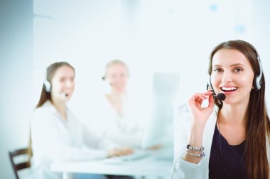 Ofisinde kulaklık ve bilgisayarla gülümseyen iş kadını ya da yardım hattı operatörü