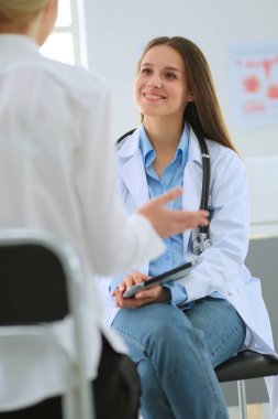 Doktor ve hasta masada otururken bir şey tartışıyorlar. İlaç ve sağlık hizmetleri kavramı