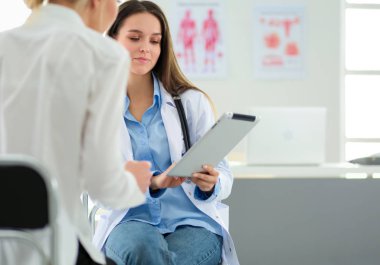 Doktor ve hasta masada otururken bir şey tartışıyorlar. İlaç ve sağlık hizmetleri kavramı