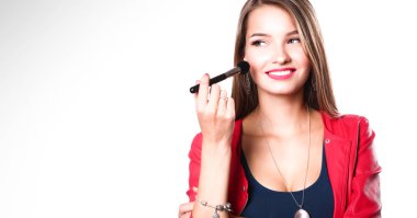 Genç güzel kadın elinde makyaj için fırça tutar