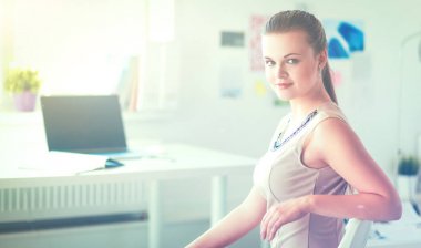 Masasında ve bilgisayarında evrakları olan bir kadın.