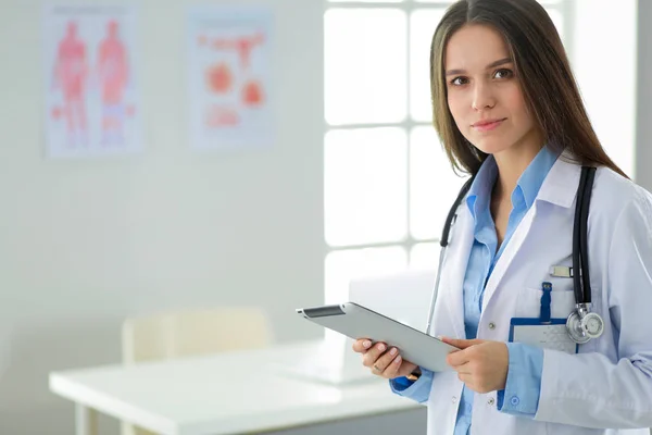 Médico femenino usando tableta en el vestíbulo del hospital —  Fotos de Stock