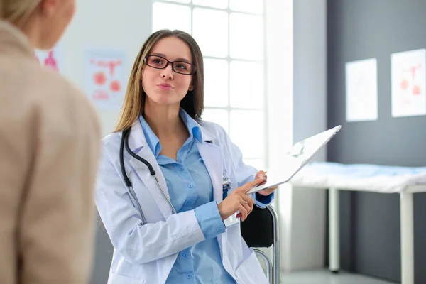 Doctor y paciente discutiendo algo mientras están sentados en la mesa. Concepto de medicina y salud — Foto de Stock