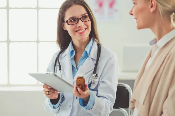 Dottore e paziente discutono di qualcosa mentre sono seduti al tavolo. Medicina e concetto di assistenza sanitaria — Foto Stock