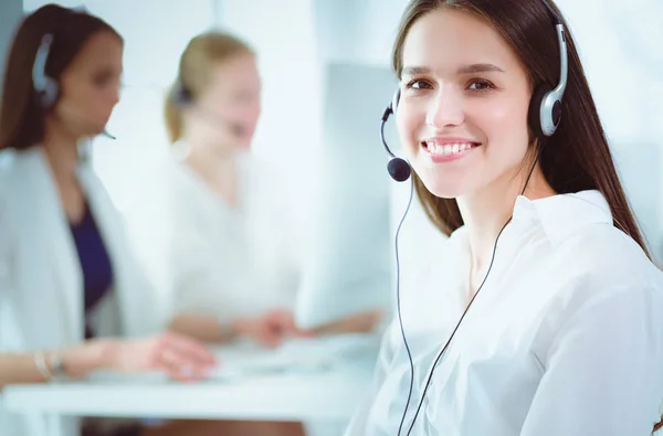 Lächelnde Geschäftsfrau oder Helpline-Betreiberin mit Headset und Computer im Büro — Stockfoto