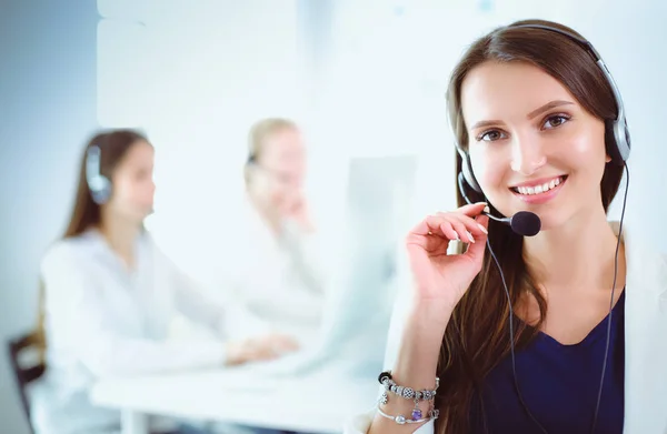 Mujer de negocios sonriente u operador de línea de ayuda con auriculares y computadora en la oficina —  Fotos de Stock