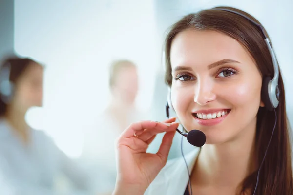 Smiling businesswoman or helpline operator with headset and computer at office — Stock Photo, Image