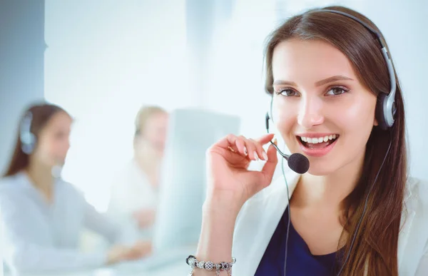 Mujer de negocios sonriente u operador de línea de ayuda con auriculares y computadora en la oficina — Foto de Stock