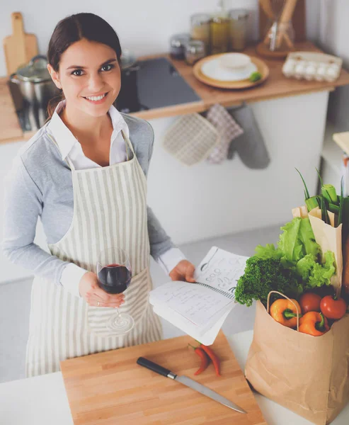 Mulher fazendo comida saudável em pé sorrindo na cozinha — Fotografia de Stock