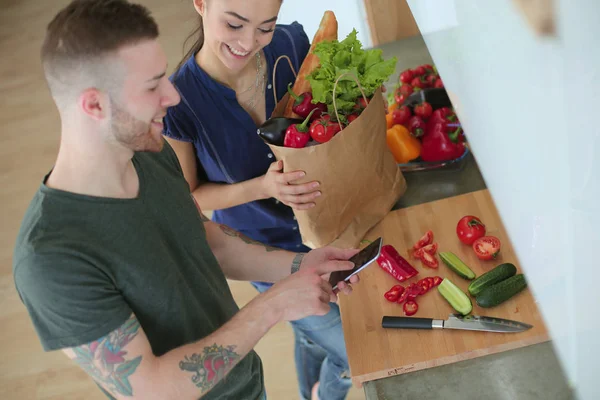 Gelukkige paar met smartphone staande in keuken — Stockfoto