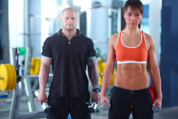 Hermosa mujer en el gimnasio haciendo ejercicio con su entrenador. Hermosa mujer . — Foto de Stock