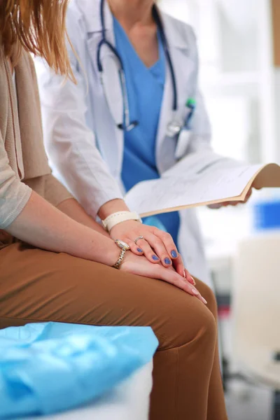 Dokter en patiënt bespreken iets terwijl ze aan tafel zitten. Geneeskunde en gezondheidszorg. Dokter en patiënt — Stockfoto