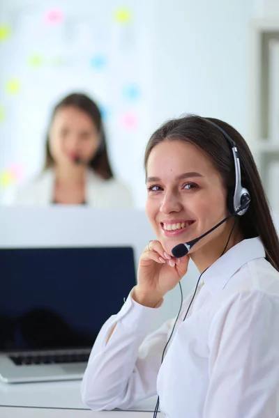 Usmívající se podnikatelka nebo operátorka telefonní linky se sluchátky a počítačem v kanceláři — Stock fotografie