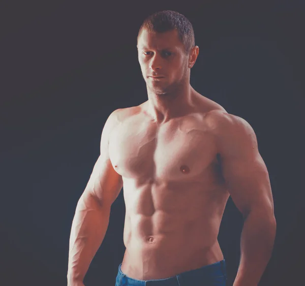 Zdrowe mięśni młody człowiek. na białym tle na czarnym tle — Zdjęcie stockowe