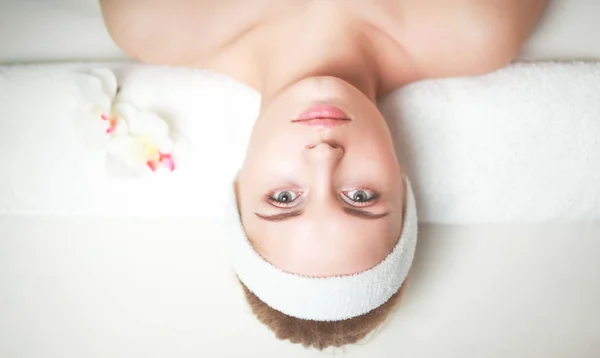 Kaunis nuori nainen saada kylpylä hieronta, makaa salonki — kuvapankkivalokuva