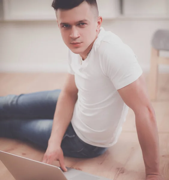 Jonge zakenman, werkzaam in kantoor zittend op de vloer — Stockfoto