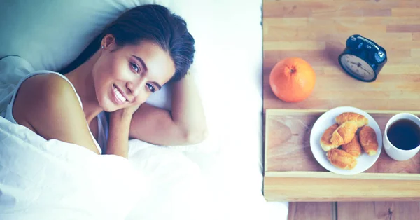 Wanita cantik muda berbaring di tempat tidur di rumah — Stok Foto