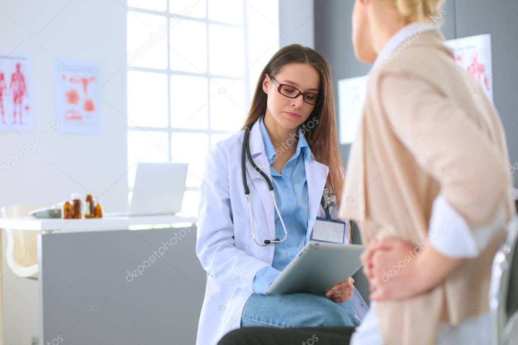 Doctor and patient discussing something while sitting at the table . Medicine and health care concept. Doctor and patient