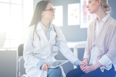 Doktor ve hasta masada otururken bir şey tartışıyorlar. İlaç ve sağlık hizmetleri kavramı
