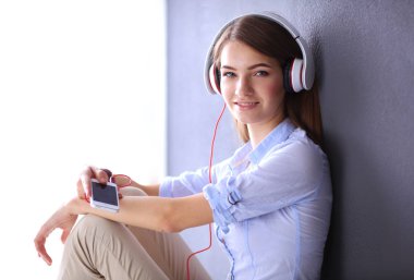 Katta oturan ve müzik dinleme genç mutlu kız