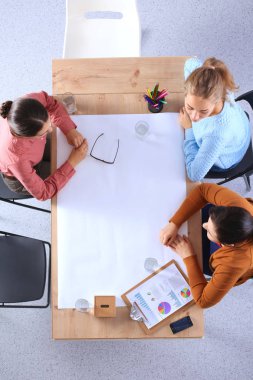 İş adamları toplantıda, ofiste oturup tartışıyorlar.