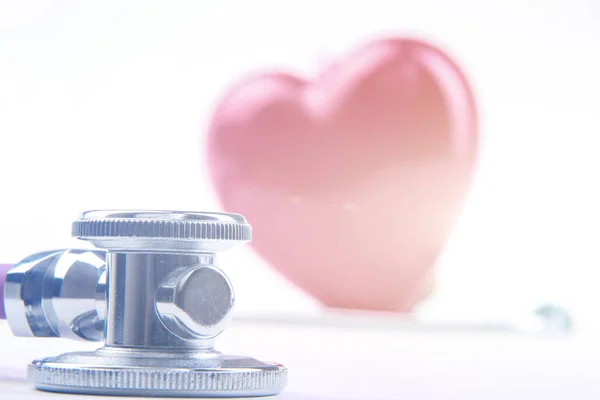 Red heart and a medical stethoscope at desk — Stock Photo, Image