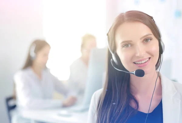 Mujer de negocios sonriente u operador de línea de ayuda con auriculares y computadora en la oficina —  Fotos de Stock