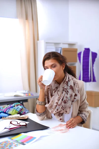 Sorrindo designer de moda feminina sentado na mesa de escritório — Fotografia de Stock